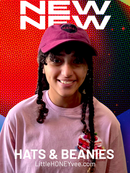 Person wearing a pink cap and shirt with 'NEW' text and 'HATS & BEANIES' text on a colorful background.