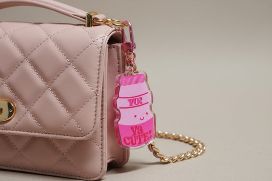  cute keychain in the shape of a pink yukilt bottle with words "yo! Ya cute" on it